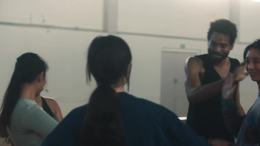 Ballet dancers exchange high fives as a gesture of celebration or camaraderie