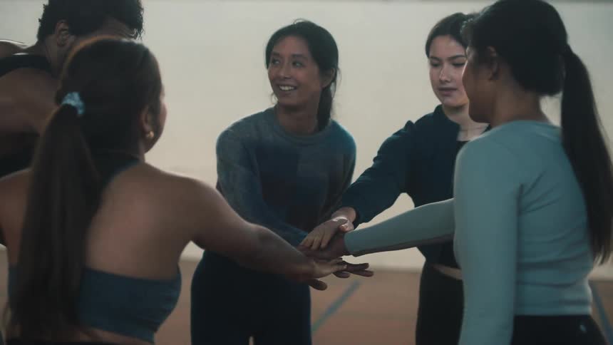 A leader man joining hands with other women and everyone raising them together