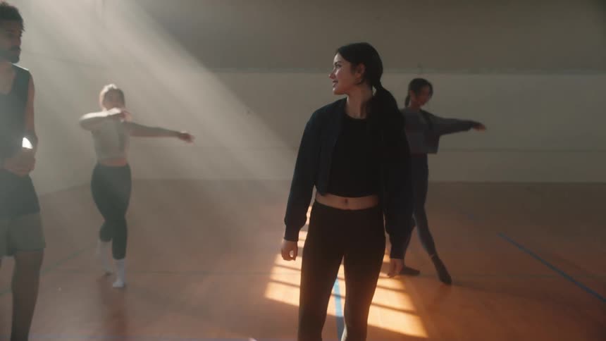 Teacher assisting his students in performing a ballet spin on an indoor court