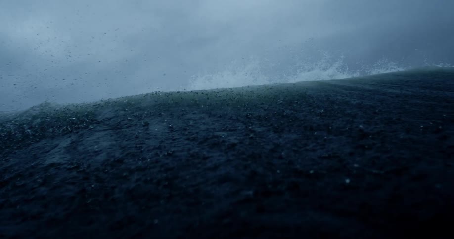 View of a sea wave breaking in slow motion on a cloudy day