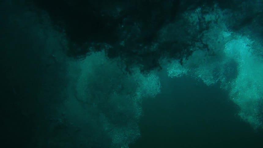 Bubbles rising to the surface of a vast body of water