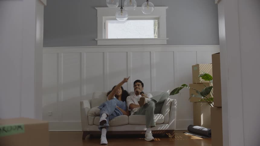A couple of a man and a woman sit on a white sofa and start talking