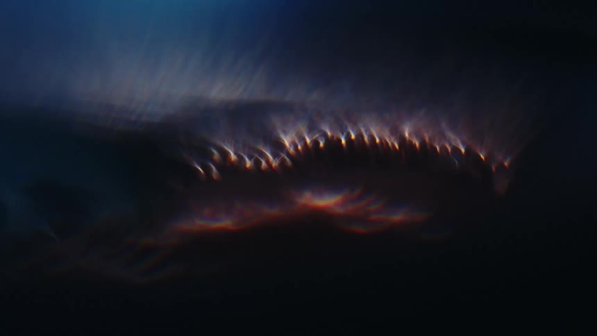 An abstract object emanating some lights and then remaining in the dark