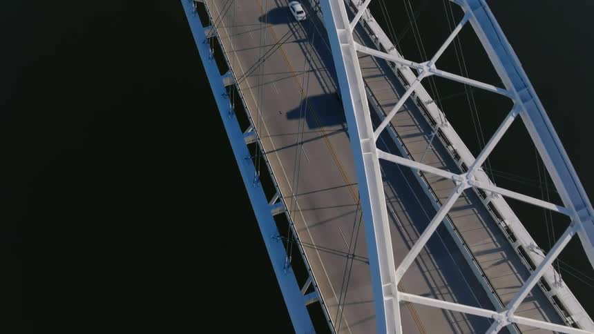 Aerial of a road bridge over a river during the day