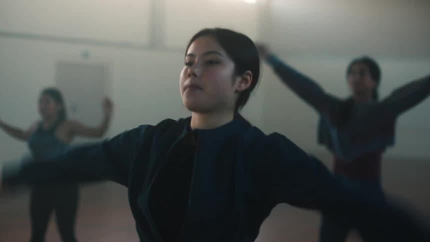 Women doing jumping jacks inside a court