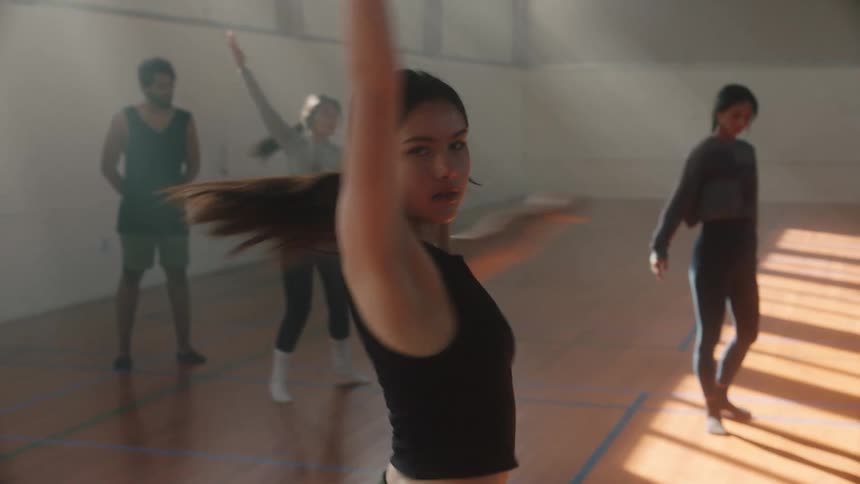 A girl doing ballet steps in a gym