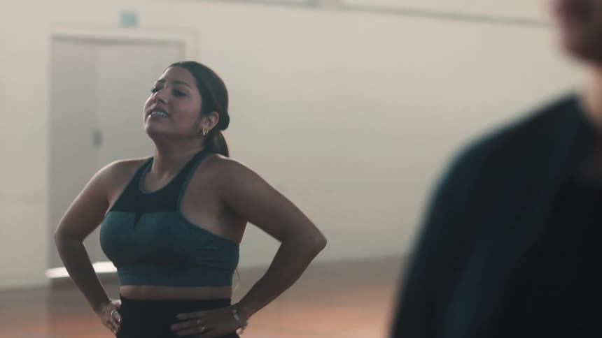 Women doing cardio hopping in sequence and the teacher congratulating them by clapping their hands