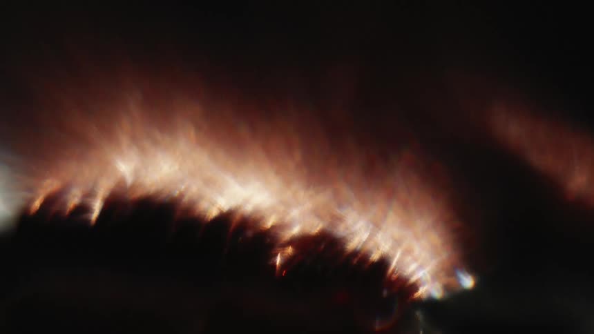 A strong light with the glow of flames in a completely dark environment