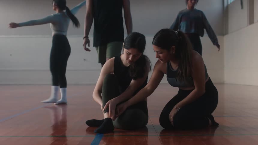 A ballet dancer injures her ankle and her friend and teacher quickly come over to check on her