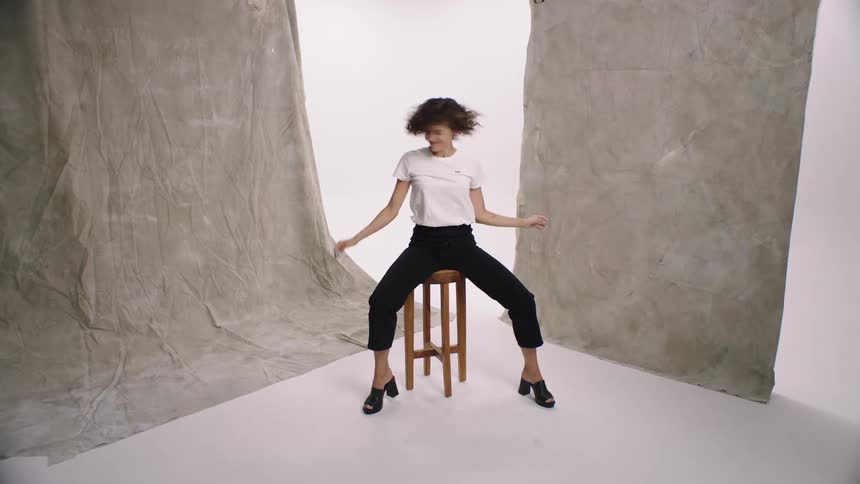 Woman modeling in a studio and sitting in a chair