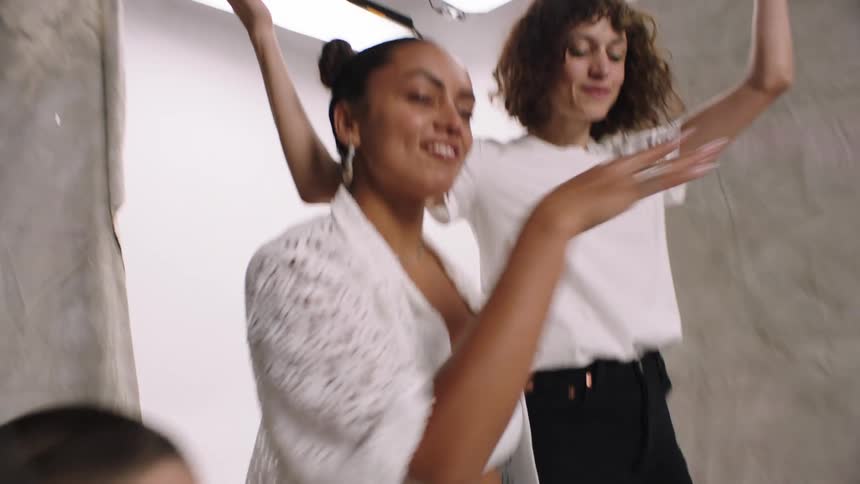 A group of three women in a photo studio are smiling and happy