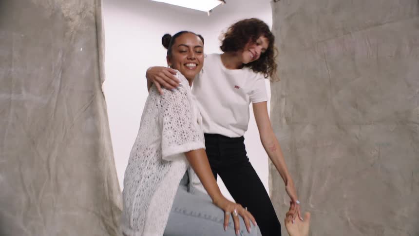 Friends in a studio modeling with one of them lying on the floor