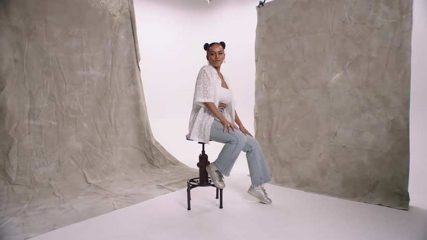 A young lady sitting happily on a stool