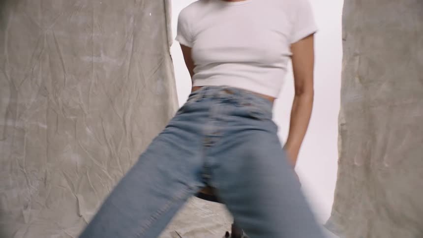 A female model wearing a jean spinning on a round chair