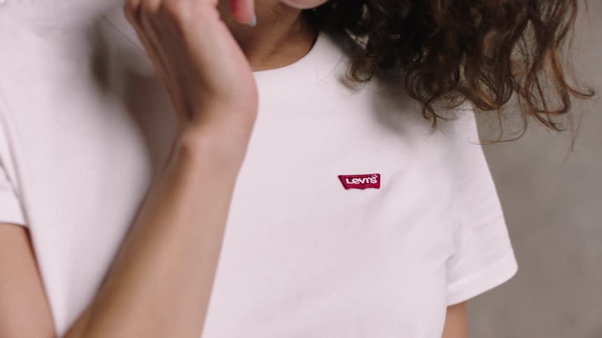 A woman smiles while posing in a tshirt