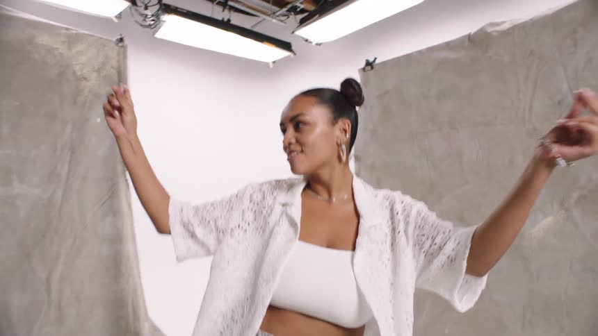 A lady dancing and smiling to the camera in the studio model modeling photography white cyc denim levi jeans