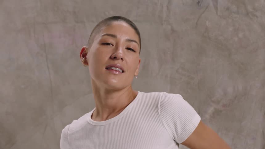A female with short hair looking happy as she moves her body from left to right