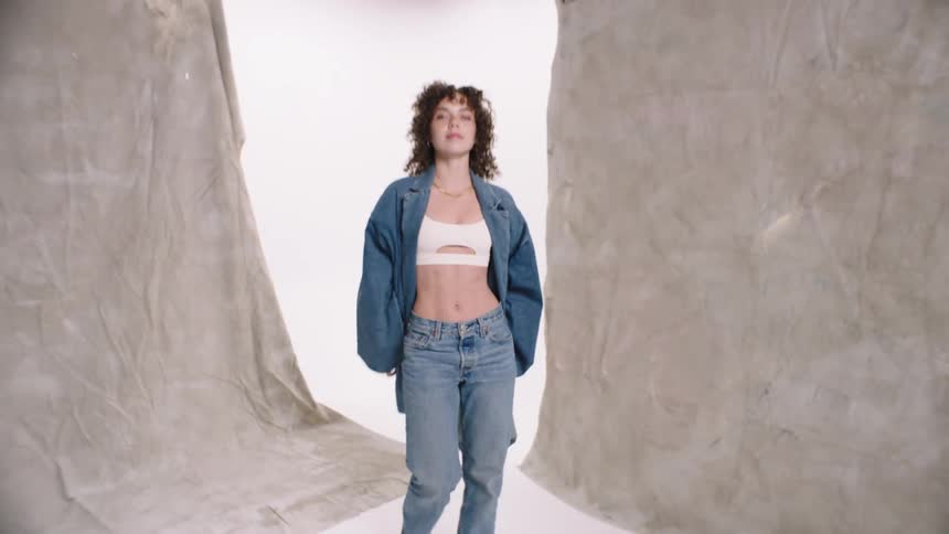 Woman modeling in jeans in a studio photo white cyc studio quirky smile with a gap in teeth