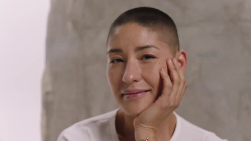 A woman passing her hand on her head and making several smiling faces