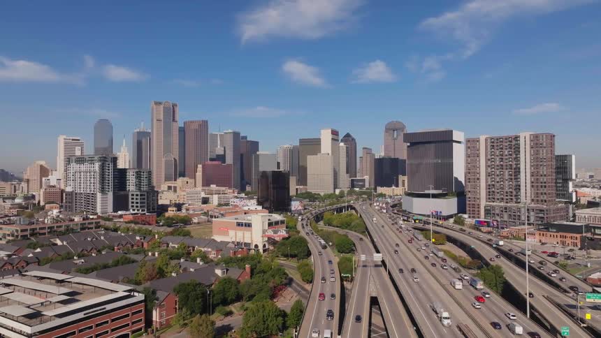 Aerial view of bustling highways with a backdrop of towering skyscrapers in the cityscape