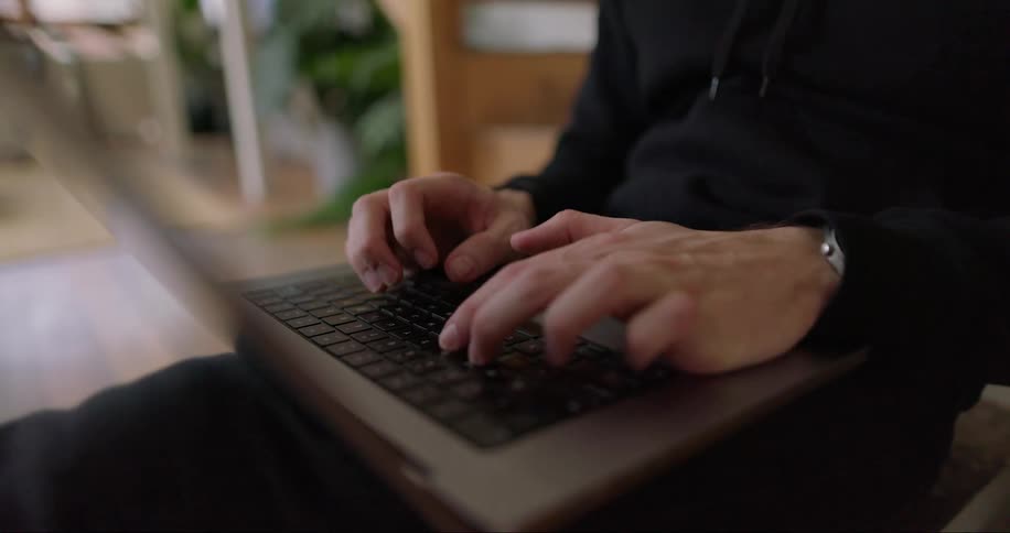 A person typing quickly on their laptop