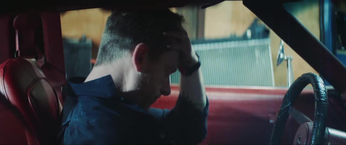 Man sitting inside the car frustrated and pounding the steering wheel