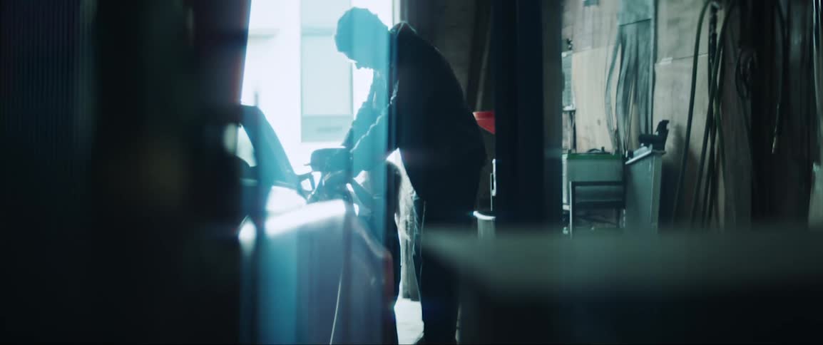 A father in a garage showing the car to his daughter