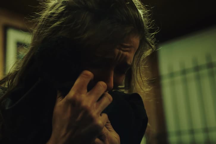 A woman crying hugging a piece of clothing