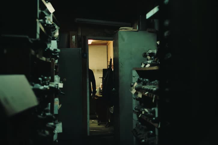 Woman with her back walking down a hallway and heading towards a room