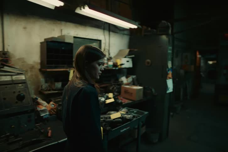 Woman walking amid a warehouse with various tools