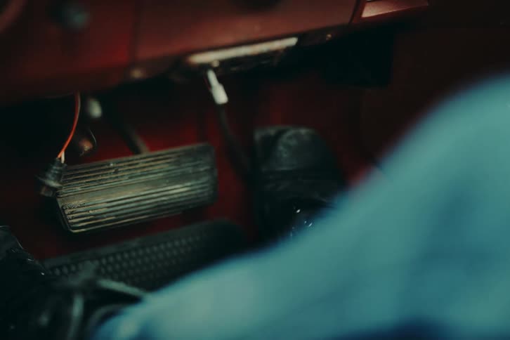 Legs and feet of a person forcefully stepping on the brakes of a vehicle