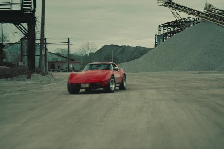 A woman driving a car on a dirt road
