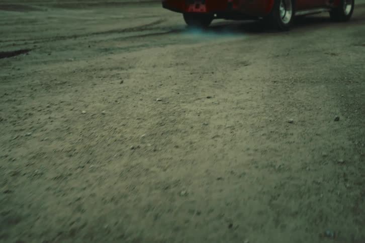 A car starting at high speed on the dirt road