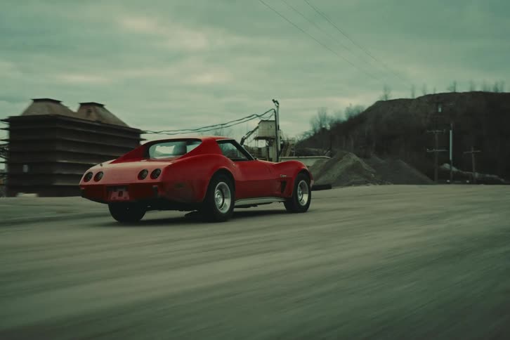 Twodoor red car driving on a dirt road