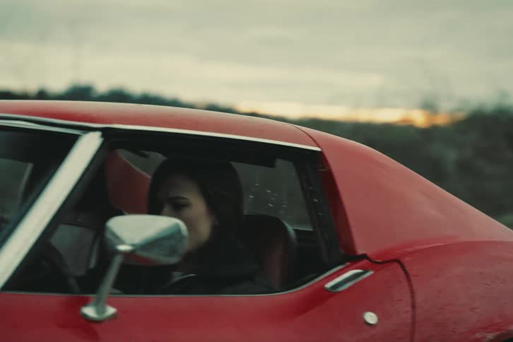 Woman driving a red twodoor car