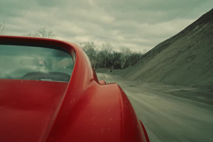 Exterior view of a classic red vehicle in motion