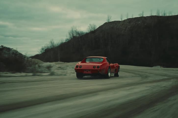 A red car at high speed making a dangerous curve