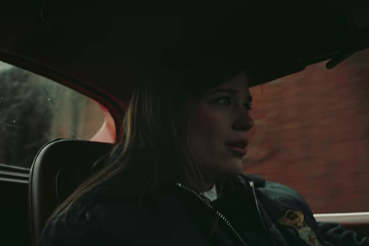 Woman driving a vehicle with a mix of emotions