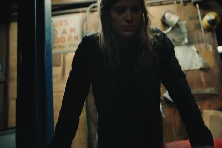 Portrait of a young woman observing the internal mechanics of the engine of an old red coup