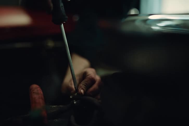 A person with a screwdriver tightening a screw