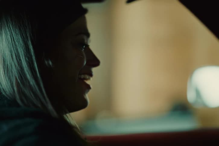 Woman starting her car and crying with emotion