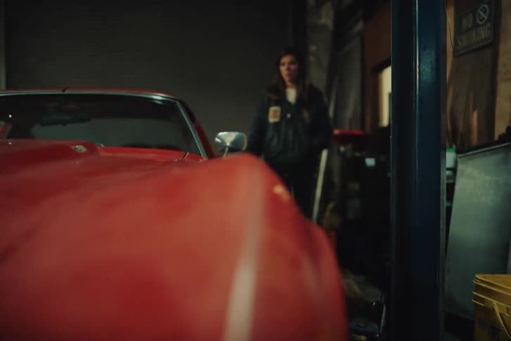 A determined woman getting into an old car in the garage