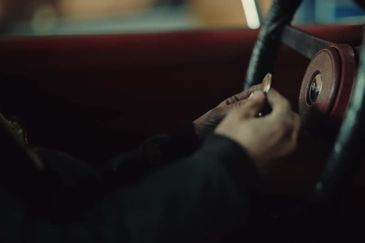A car with a driver behind the wheel who searches for and finds the car keys in the visor