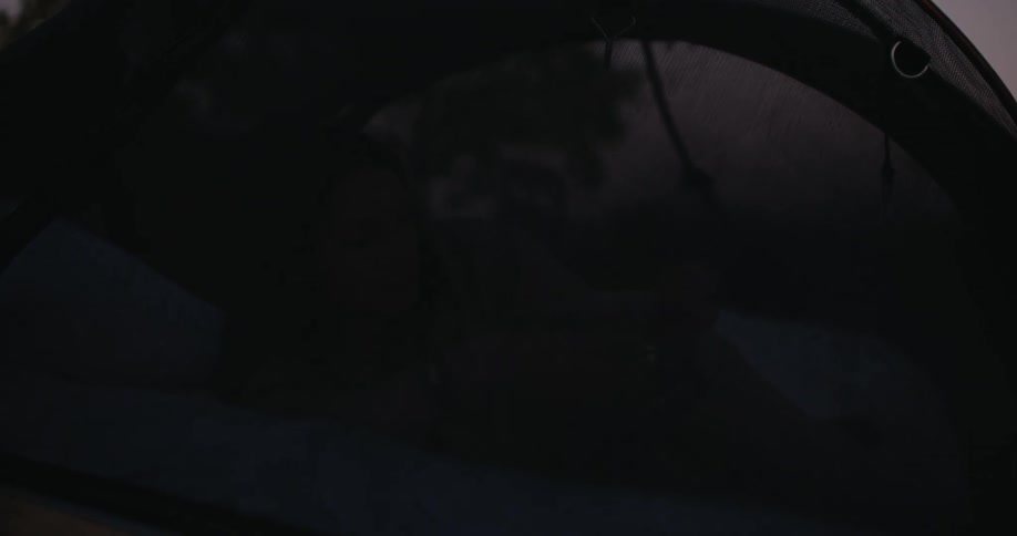 A woman lying on the tent bed at night