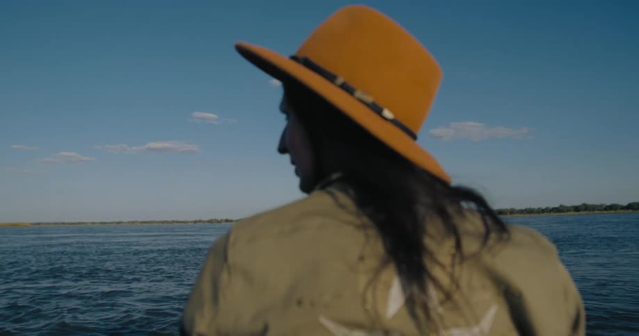 A woman scans the water of the lake on a bright sunny day