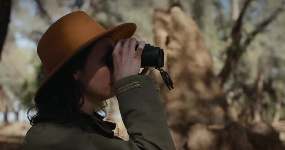 Portrait of a woman in the midst of nature using binoculars