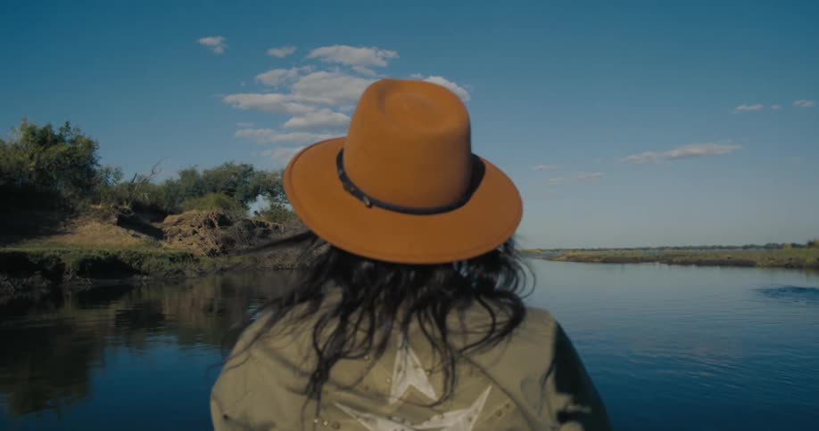 Woman walking on the deck of a boat in the middle of a river