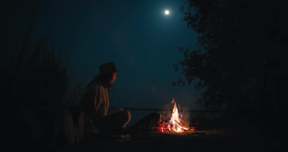 A woman is camping under the moon light