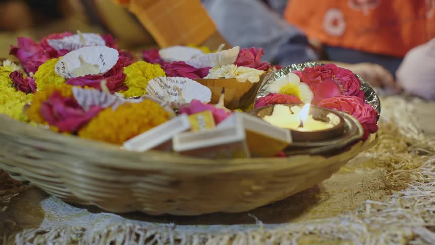 A candle flickers in the basket full of flowers