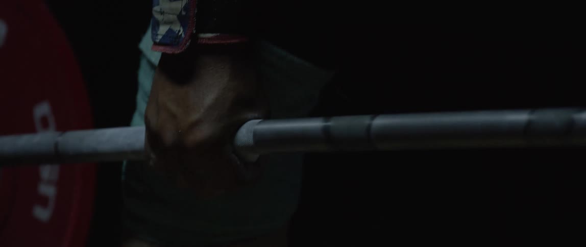 A strong man lifting a barbell with weight plates